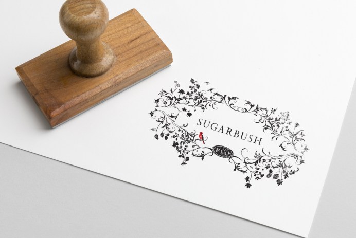 A stamped impression of a logo with the word sugarbush in the middle of branches and birds.