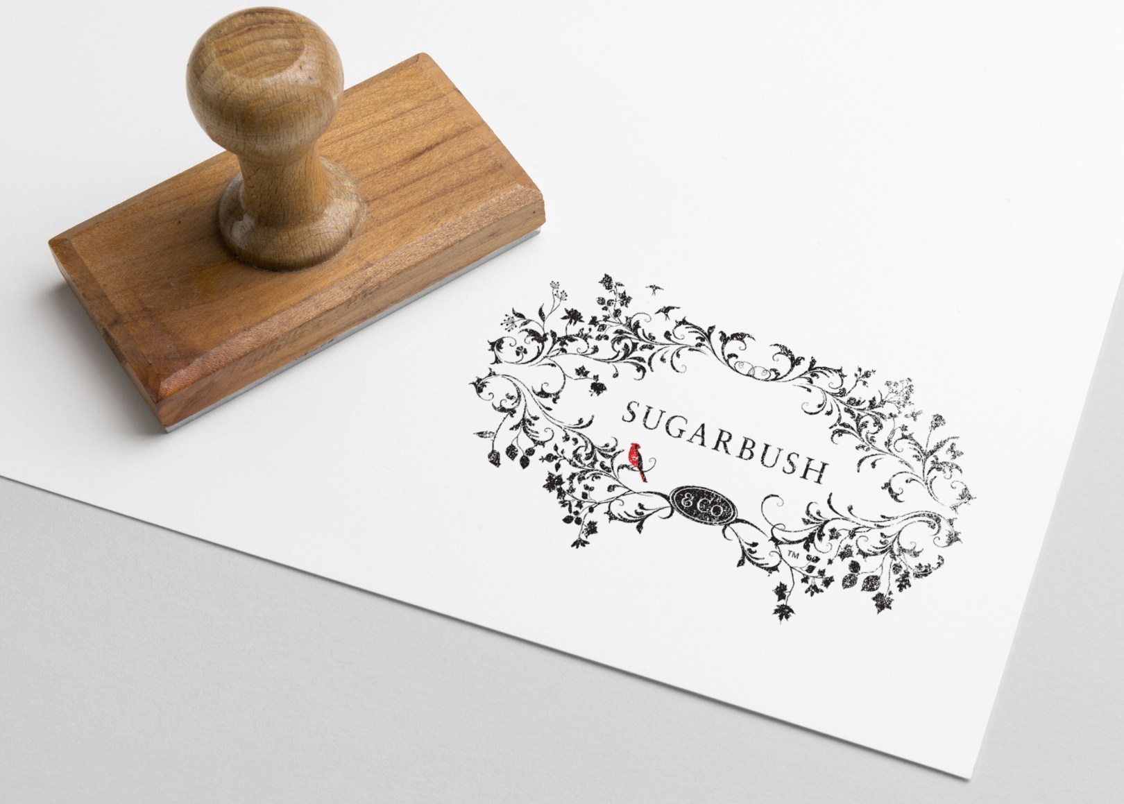 A stamped impression of a logo with the word sugarbush in the middle of branches and birds.